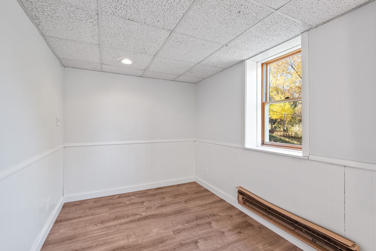 services-05 Bright empty room with wooden floor and window. Ideal for real estate or renovation projects.