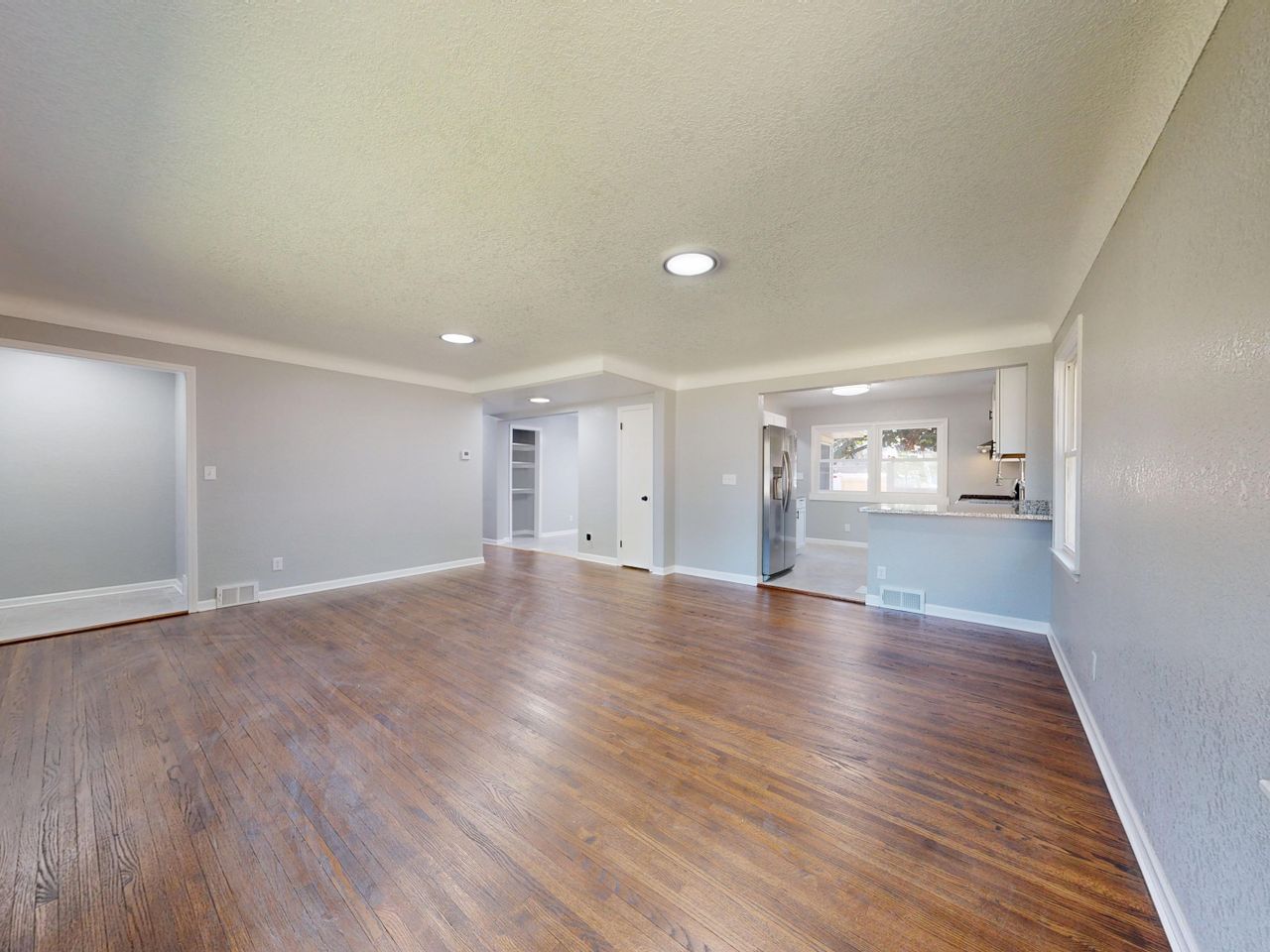 gallery-05 Open and bright living room with hardwood floors and natural light.
