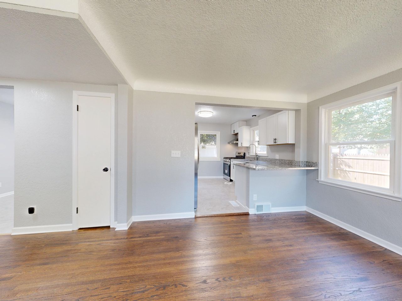 portfolio-02 Modern kitchen and dining area with hardwood floors and natural light.