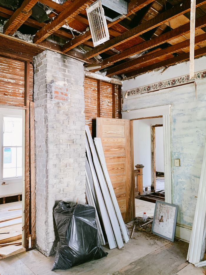 gallery-01 Exposed wooden beams and brickwork highlight a house interior undergoing renovation.