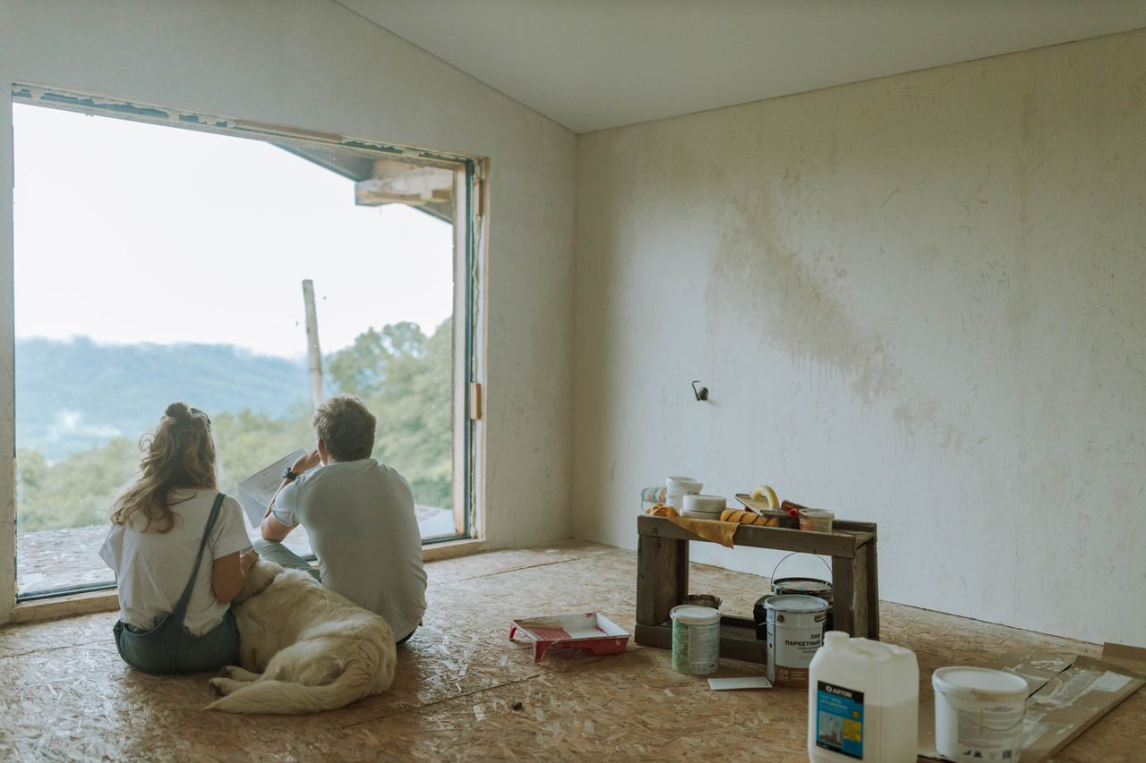 gallery-06 A couple with their dog resting in a partially renovated room, planning the renovation.