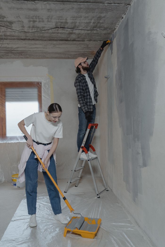 portfolio-01 Young couple painting walls and doing home renovation together.